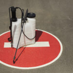 Background image of disinfection equipment standing on red STOP sign outdoors in sunlight, cleaning and prevention concept, copy space
